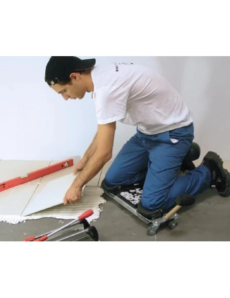 Carreleur en situation utilisant le Siège ergonomique SR-1 RUBI pour poser des carreaux au sol, vue latérale.