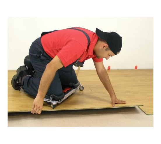 Carreleur en situation, utilisant le siège ergonomique SR-1 RUBI pour poser du carrelage, vue latérale.