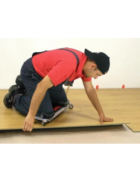 Carreleur en situation, utilisant le siège ergonomique SR-1 RUBI pour poser du carrelage, vue latérale.