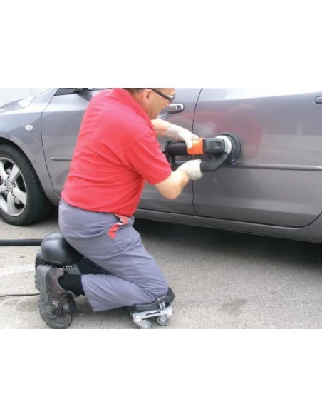 Siège ergonomique SR-1 RUBI en situation, carreleur agenouillé polissant une surface latérale de voiture.