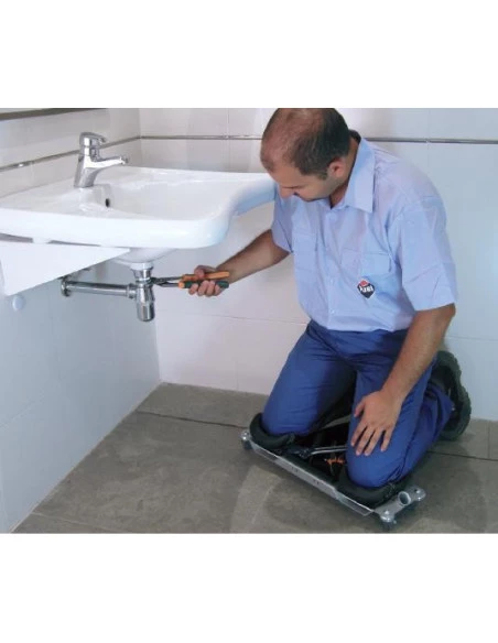 Carreleur utilisant le Siège ergonomique SR-1 RUBI en situation, agenouillé sous un lavabo, vue d'ensemble.