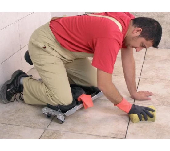 Carreleur en situation, utilisant le Siège ergonomique SR-1 RUBI pour le nettoyage des joints de carrelage.